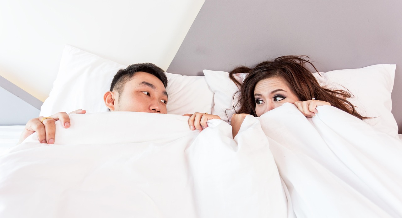 情侶在床上親密擁抱，表情滿足幸福